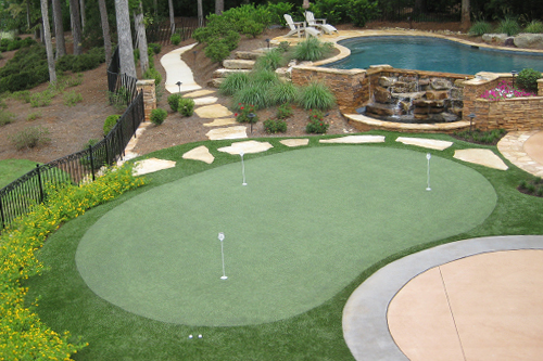 Putting green with rock pathway to swimming pool