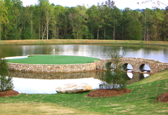 recreation of Augusta National's hole 12 - a small putting green on an island with a rock bridge connecting to the rest of the course